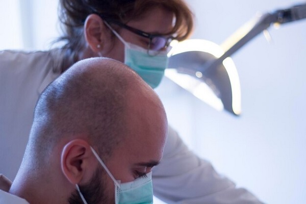 Implante capilar - especialista en la consulta con un paciente con problemas de alopecia