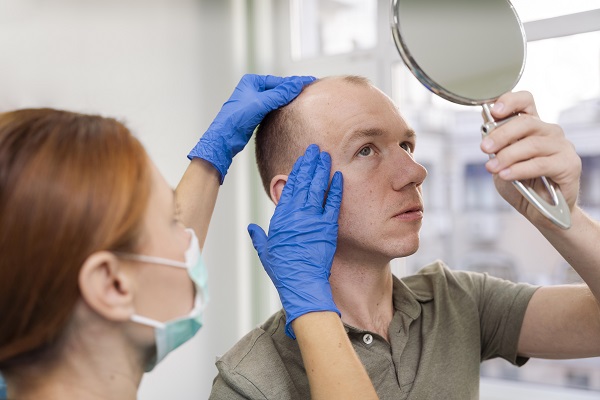 tricóloga explicando a un paciente la realización del injerto de cabello