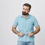 Prostatitis por excesos sexuales - hombre se toma con la manos la zona del estomago