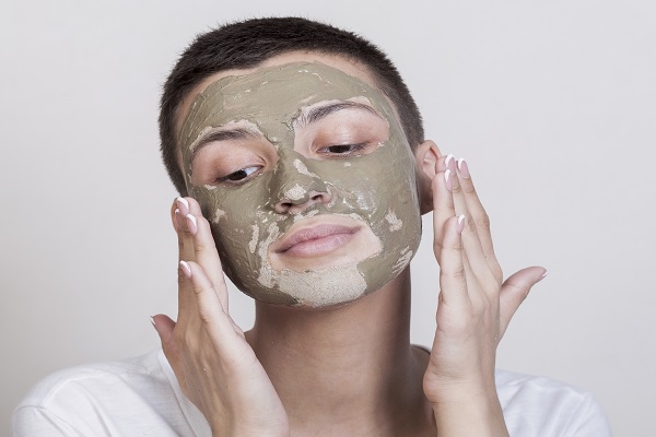 Tratamientos dermatológicos - mujer se aplica una mascarilla de arcilla en la cara, para disminuir la piel grasa