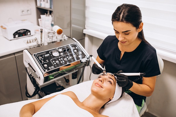 tratamientos dermatológicos - mujer recibe un tratamiento en la cara, a manos de una experta