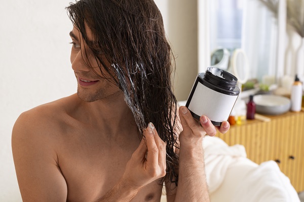 hombre apliandose su rutina de cuidado para el cabello
