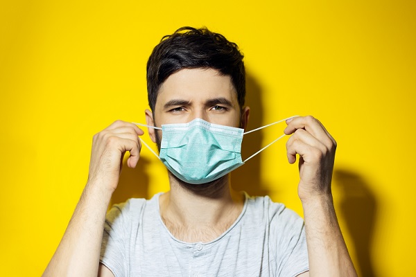 hombre se pone mascarilla, lo cual es una medida para prevenir la tosferina