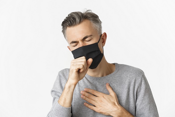 hombre adulto, con tapabocas tiene un ataque de tosferina