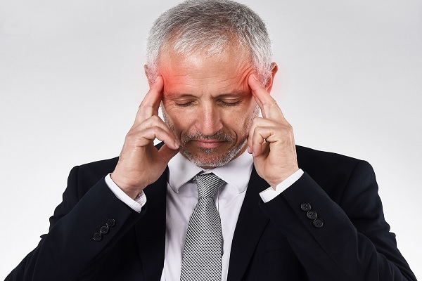 neurología clínica, hombre anciano con sus dedos en los laterales de su cabeza, tratando de soportar el dolor de cabeza