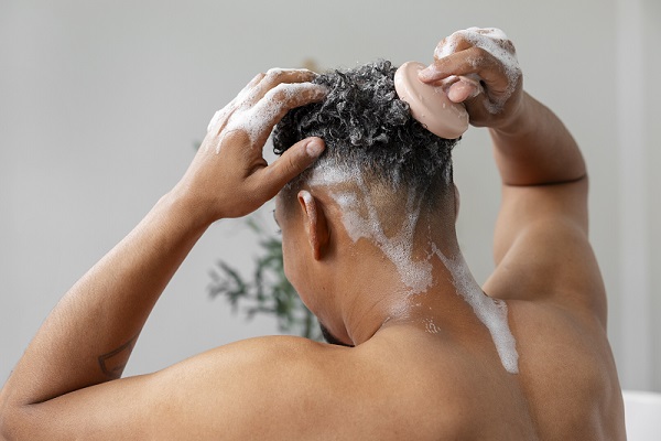 Postoperatorio implante capilar, hombre lavandose el cabello para cuidar la salud capilar, lo que también es recomendado hacer para cuidar el injerto capilar