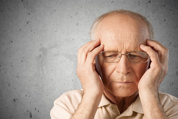 alzheimer en México - hombre anciano con las manos a los lados de su cabeza, luciendo un poco confundido
