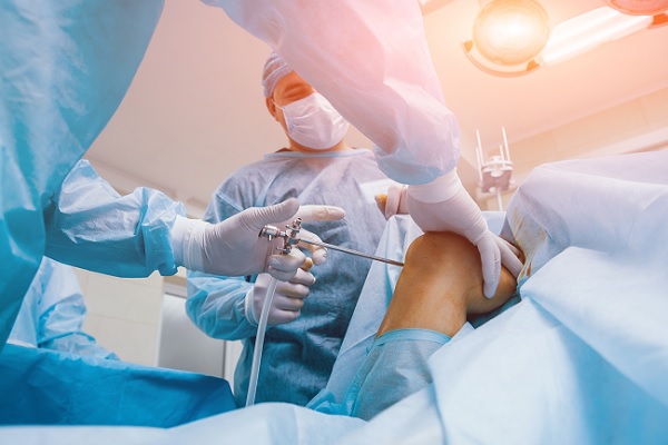 un cirujano utiliza un artroscopio para un intervención en la rodilla de un paciente
