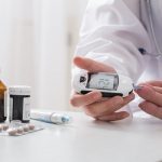 diabetes, un especialista examina el nivel de glucosa en la sangre de paciente con un medidor especial, en su consultorio
