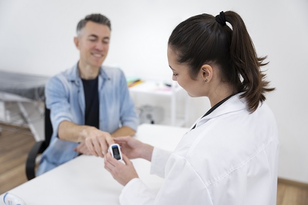una especialista le mide el azúcar en la sangre a un hombre diabético, para determinar que tipo de tratamiento es el mejor para este paciente 