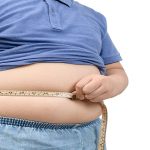 síndrome metabólico en niños - un niño obeso con una cinta de medir en su estomafo