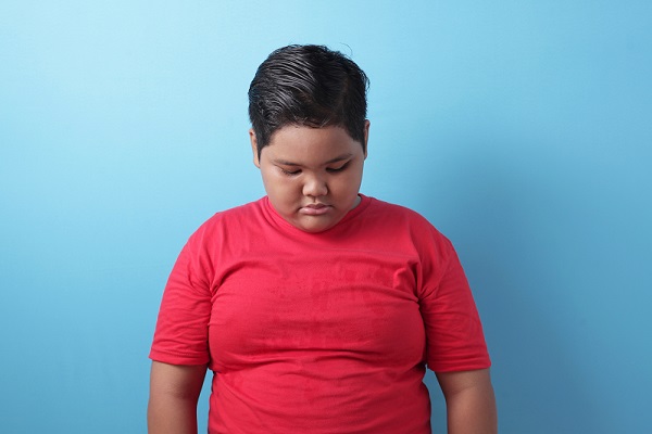 síndrome metabólico en niños, un niño con obesidad con la cabeza agachada