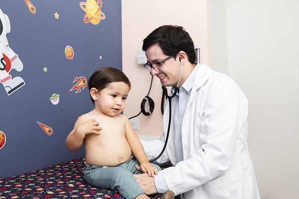 síndrome metabólico en niños, un medico examinando a un niño con un poco de grasa abdominal, para descartar este síndrome