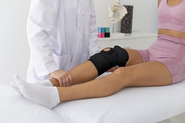 Tratamiento para desgarro de meniscos, mujer con inmovilizador en su rodilla derecha
