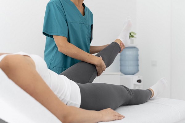 Tratamiento para desgarro de meniscos, una mujer recibe fisioterapia en una rodilla de un profesional