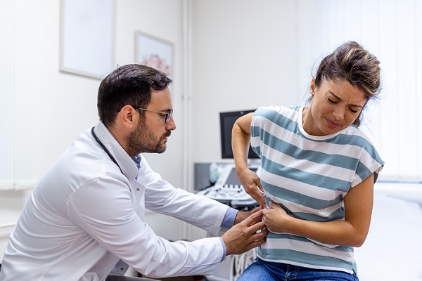 glomerulonefritis. un especialista examina a paciente femenina con dolor en la zona del riñón 