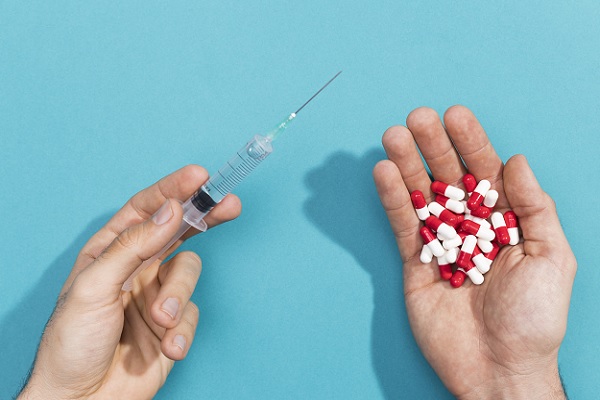 una persona sostiene pastillas en una mano y en la otra una inyección, que son posibles tratamientos para esta enfermedad renal