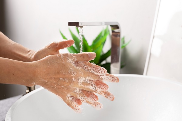 persona lavándose las manos con abundante jabón y agua