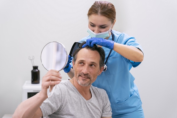 trasplante de cabello, un hombre en procedimiento capilar, mientras sonríe y observa con un espejo