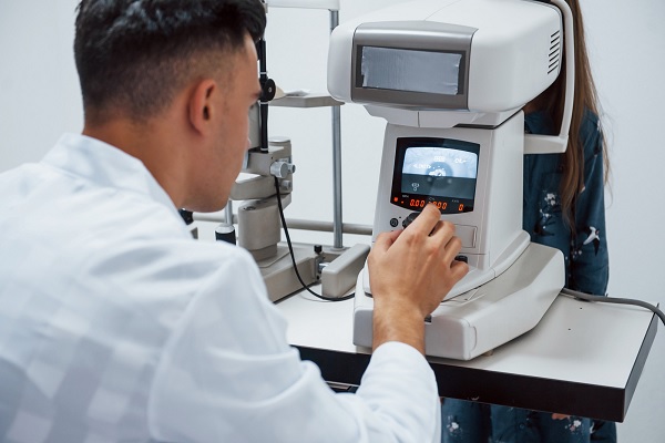oculista prueba la visión del paciente mediante el uso de una máquina moderna especial