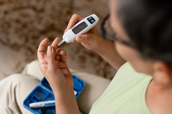 enfermedades más comunes en México - una mujer adulta con diabetes, midiendo el nivel de glucosa en su sangre