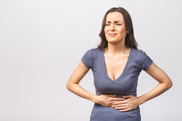 enfermedades más comunes en México - una mujer con fuerte dolor abdominal, a causa de una infección intestinal