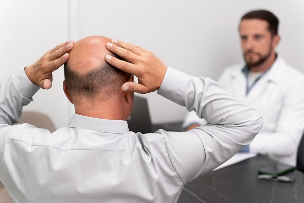 trasplante de cabello precio - hombre con alopecia en oficina de tricólogo se informa acerca del procedimiento de restauración capilar