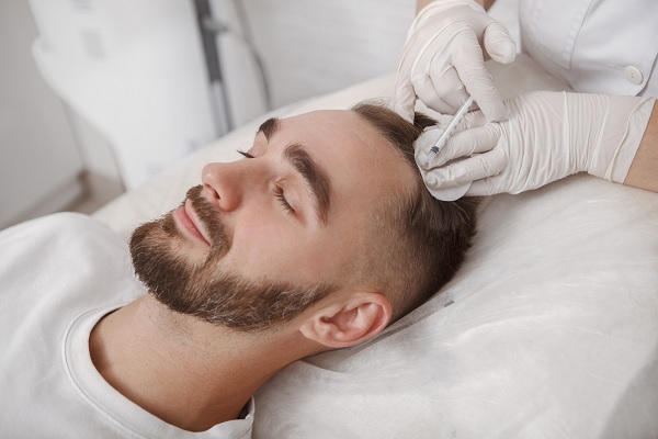 hombre joven sometiéndose a un procedimiento para alopecia